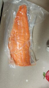 A filet of Chinook Salmon in a vacuum filled bag, preparing to cook.