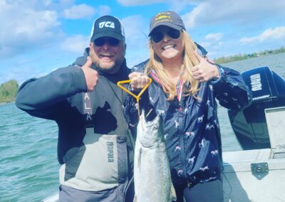 Happy woman with a salmon she caught fishing with Guide Marvin