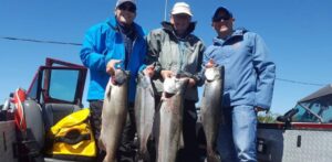 Three clients holding chinook salmon caught on the Columbia River around Astoria Buoy 10