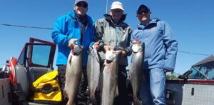 Astoria Oregon fishing guide holding limits of salmon caught on the Columbia River.