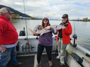 A very happy client holding a sturgeon that she caught on the Willamette River in the Portland OR area.