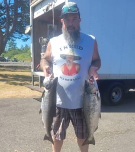 A happy customer of Marvin's Guide Service holds up chinook salmon he caught fishing on the Pacific Ocean west of Astoria, Oregon.