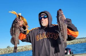 An angler holds up two big rockfish and a keeper Dungeness crab caught with Marvin's Guide Service near Astoria, Oregon.