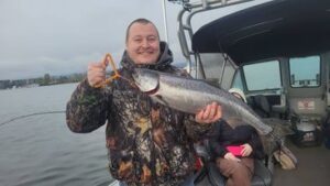 Smiling angler holds up a spring chinook salmon he caught with Marvin's Guide Service on Saturday, April 6, 2024.